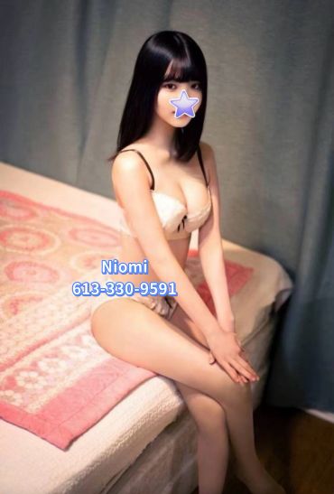 Young woman sitting on bed in lingerie.