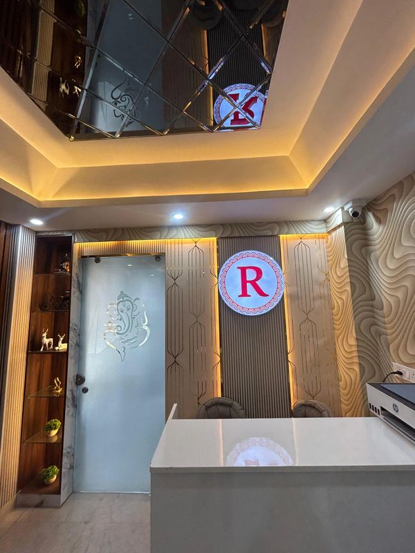 Modern reception area with illuminated 'R' logo and decorative glass door.