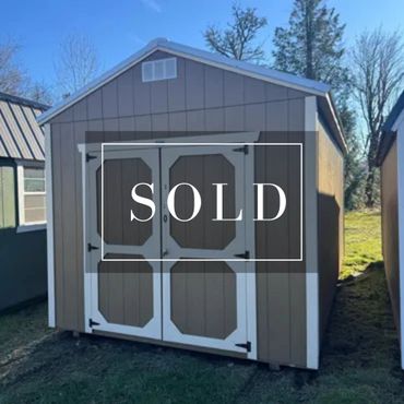 A small wooden storage shed with double doors, labeled SOLD.
