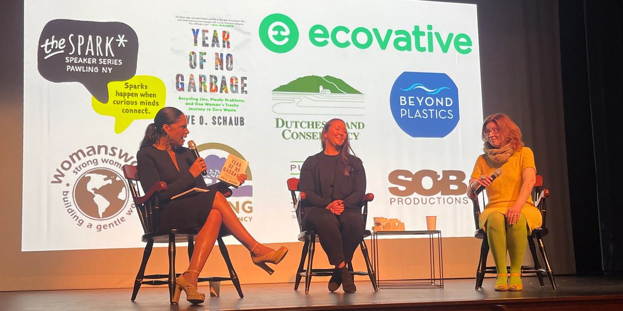 Three women on stage discussing sustainability and environmental topics in a panel setting.