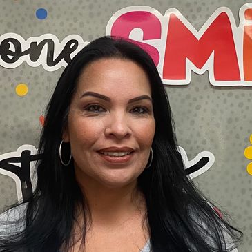 Woman smiling in front of a colorful background.