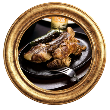 Costillas asadas en plato negro con tenedor.