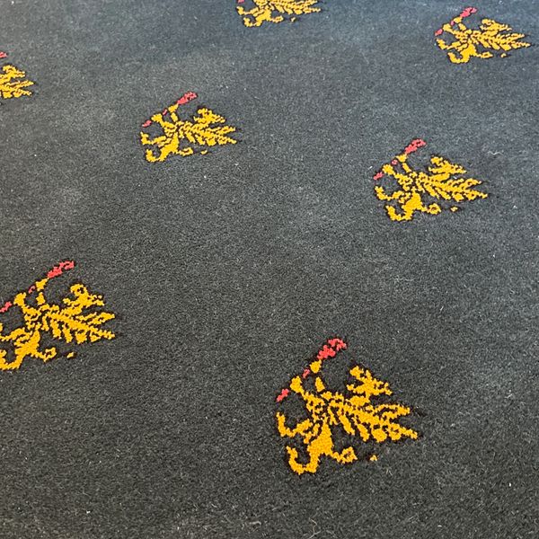 Dark carpet with yellow and red lion motifs.