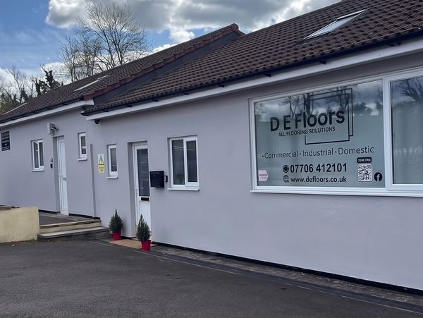 Building with DE Floors signage for flooring solutions.