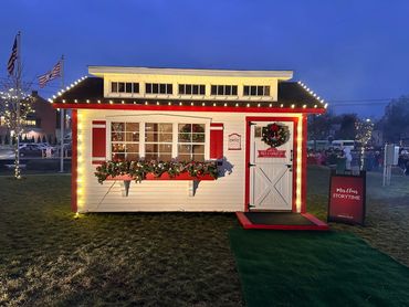 Festive Christmas cottage decorated with lights and wreaths for Mrs. Claus Storytime.