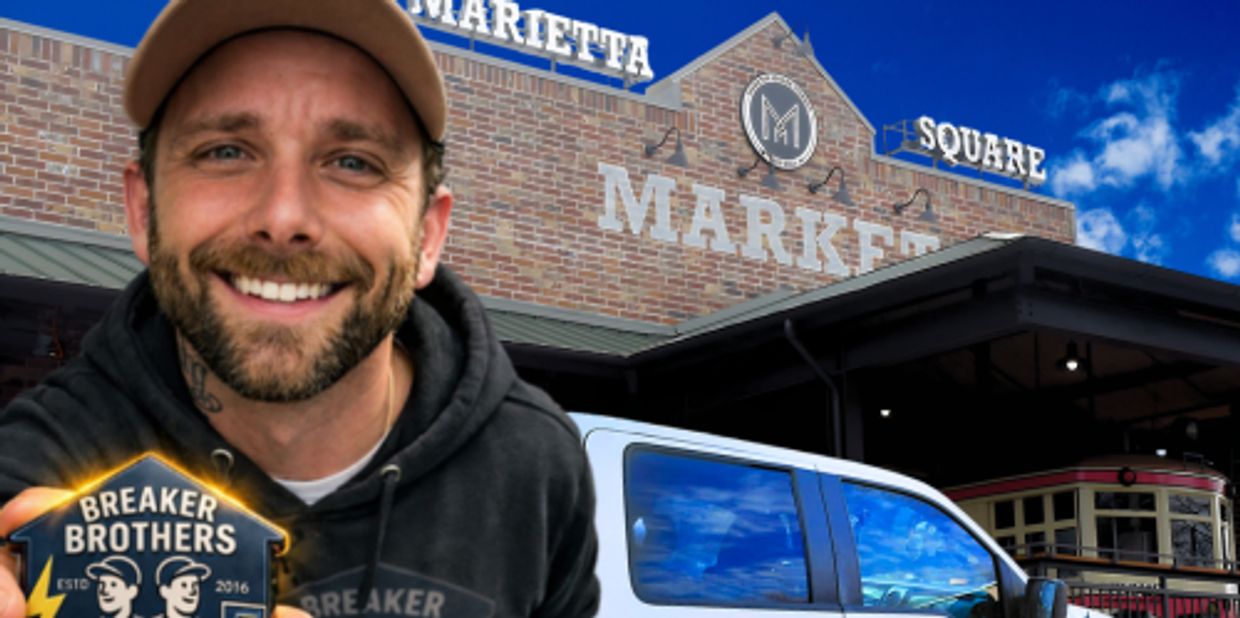 Smiling man in front of Marietta Square Market holding Breaker Brothers sign.