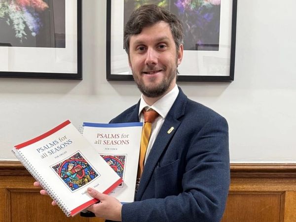 Image of Matthew JC Ward holding two song books