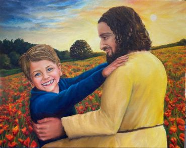 A man embraces a smiling boy in a flower field at sunset.