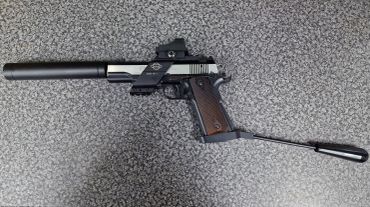 A pistol equipped with a silencer and an extended stock.