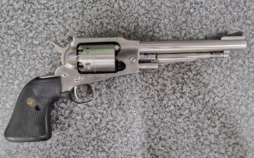 Silver revolver with black grip on granite surface.