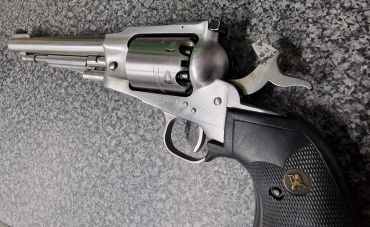Silver revolver pistol on a gray surface.