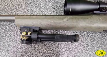 A sniper rifle with scope and bipod grip.