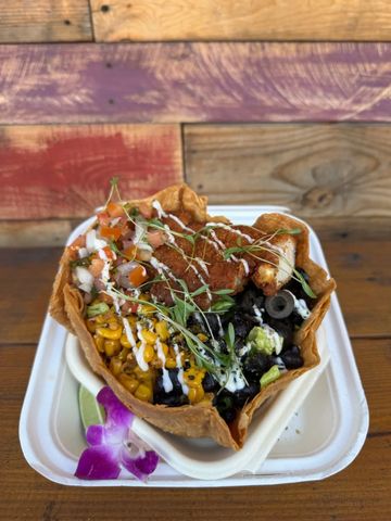 Taco bowl with fried chicken, corn, black beans, and fresh toppings.