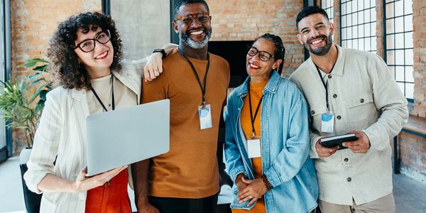 Diverse group of smiling professionals posing in a modern office.