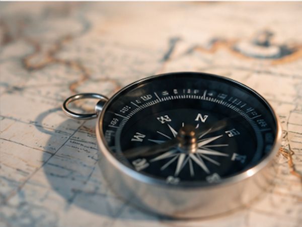A compass resting on a vintage map.