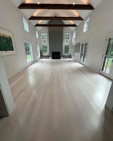 Spacious living room with vaulted ceiling and wooden beams.