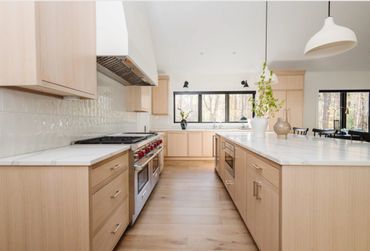 Bright modern kitchen with light wood cabinetry and large island.