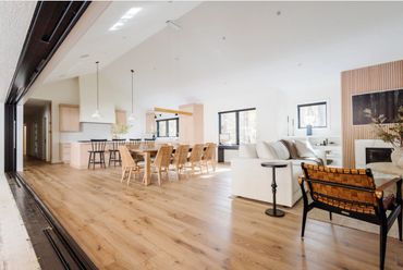 Bright, open-concept living and dining area with natural wood flooring and modern furniture.