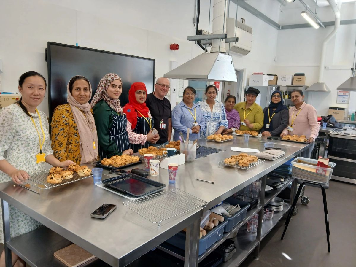 Community members cooking and sharing food together in a community kitchen in Liverpool.