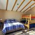 A wide view of a guest room with a bunk bed and a single bed.