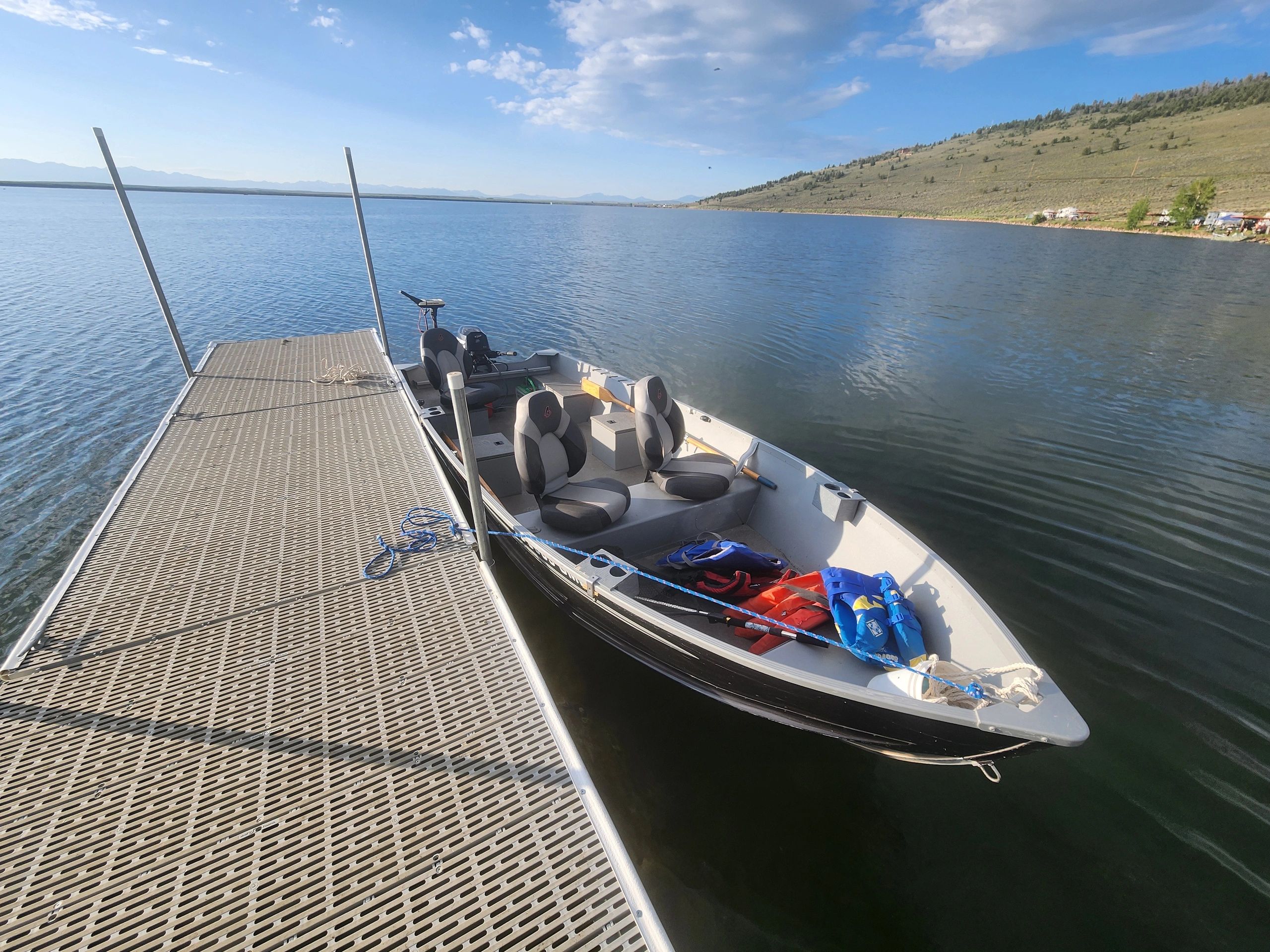 a boat is tied to a dock on a lake