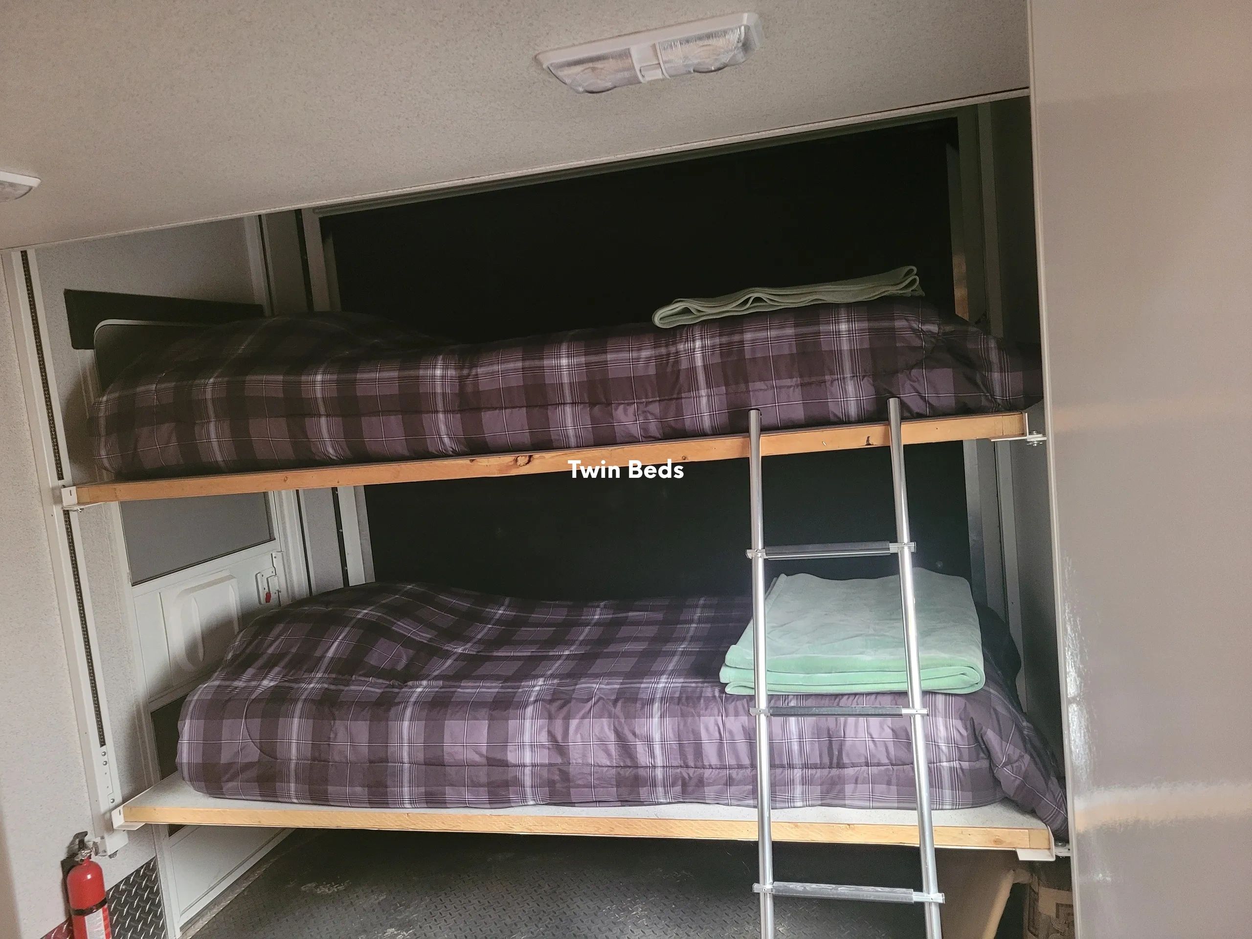 A set of bunk beds with plaid bedding and a ladder