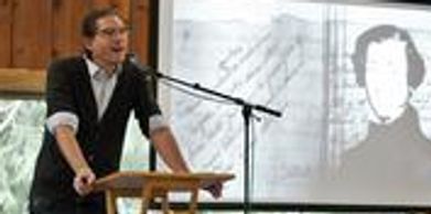 Man speaking at a podium with a microphone.