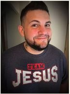 Smiling man wearing a "Team Jesus" shirt.