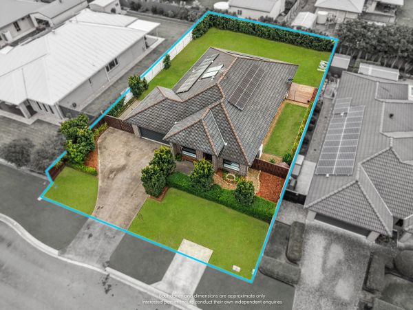 Aerial view of a house with a spacious green yard and driveway.