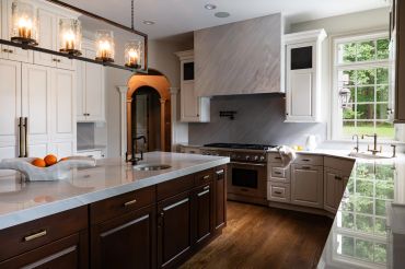 Modern kitchen with large island and pendant lights.