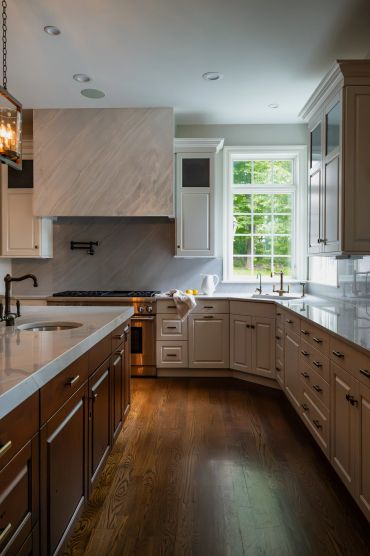 Modern kitchen with wood floor and marble countertops.