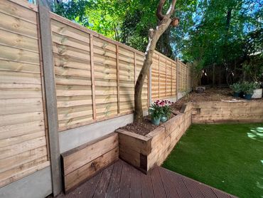 Lapped fence panels with concrete posts and gravel boards