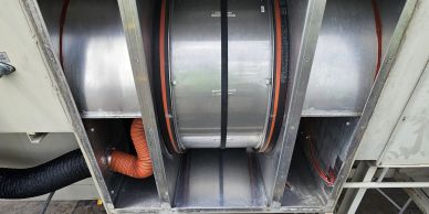 Large metal industrial drum inside a machine.