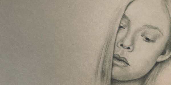 Pensive woman with downcast eyes in monochrome.