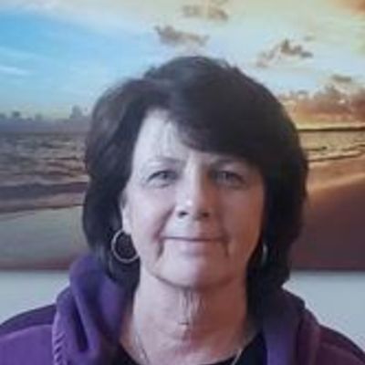 Portrait of a woman with a beach background.