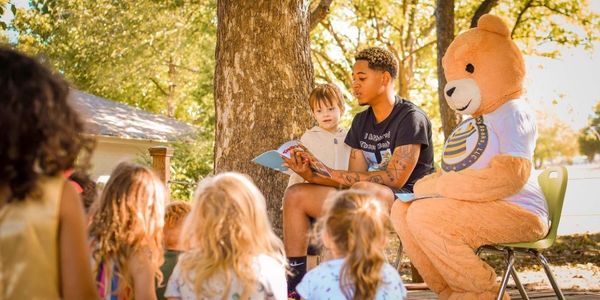 Franklin reading a book in front of toddlers