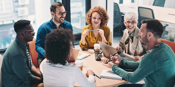 Group of people in an office smiling and talking.