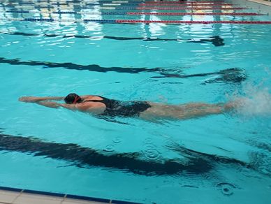Swimmer gliding underwater in a pool lane.