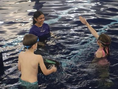 Children and instructor enjoying a swimming lesson in the pool.