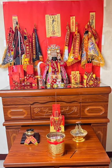 Traditional Chinese altar with colorful banners and offerings.