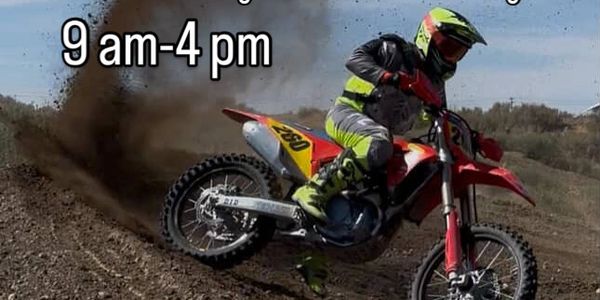 Motocross rider kicking up dirt with event details for open practice weekend.