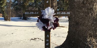 Personalized cross grave marker with name and dates of your loved one placed at a gravesite.