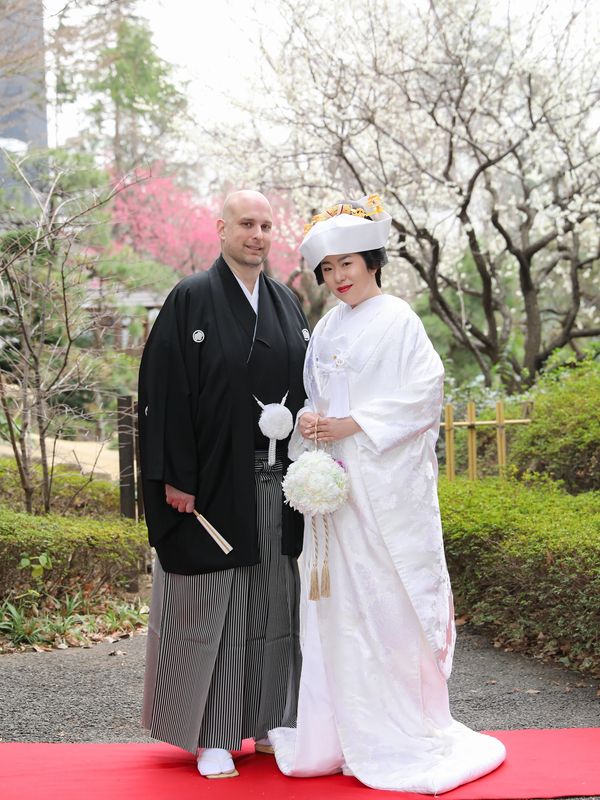 Paul and Saori McClure in traditional Japanese wedding attire in a garden