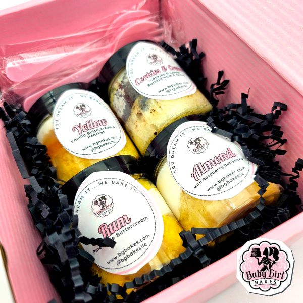 Assorted cupcake jars with various flavors inside a pink gift box.