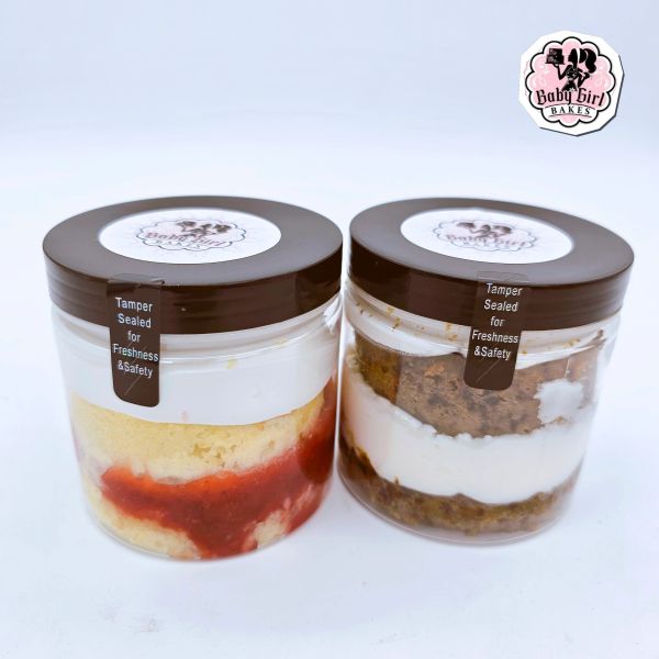 Two sealed jars of layered cakes from Baby Girl Bakes.
