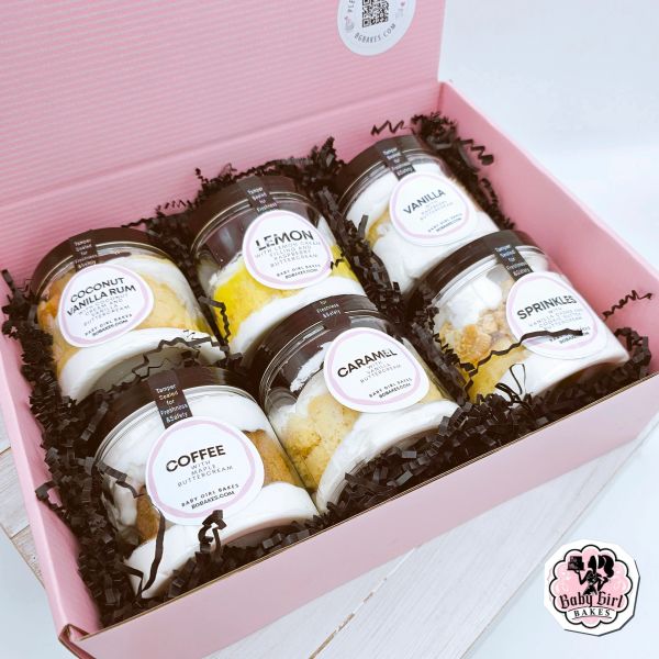 Assorted jar desserts in a pink box from Baby Girl Bakes.