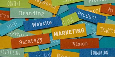 Colorful paper strips with marketing-related words scattered on a surface.