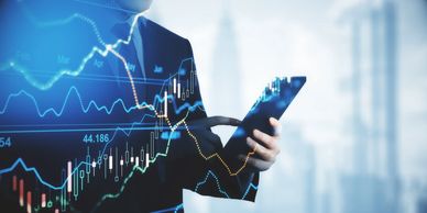 Businessman analyzing stock data on a tablet with financial charts overlay.