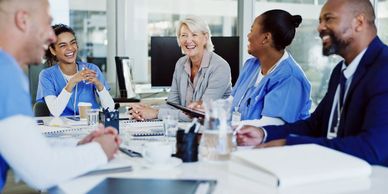 Medical team and professional smiling during a meeting in a modern office.