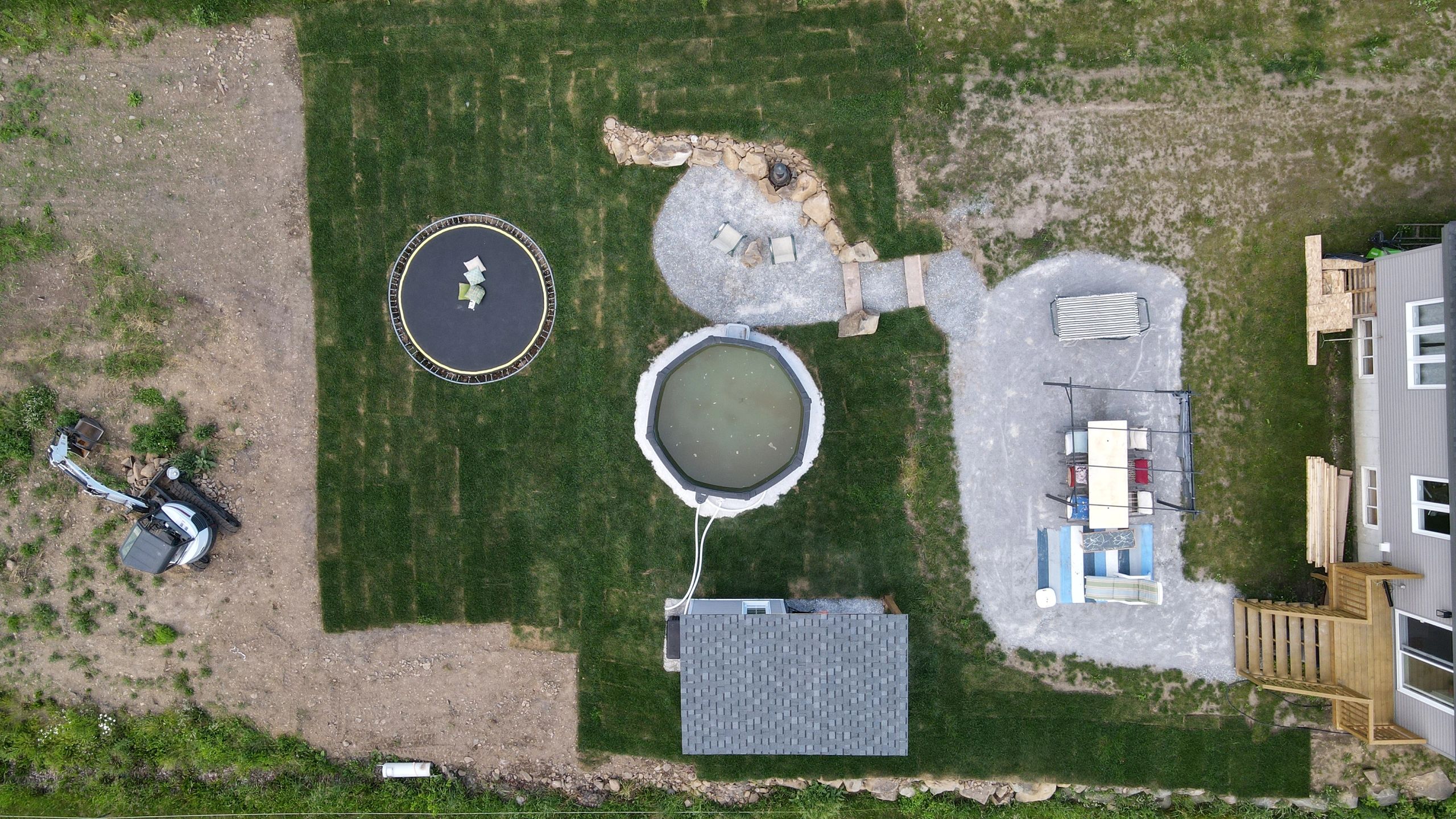 Vue aérienne d'une cour avec trampoline, piscine, et terrasse.